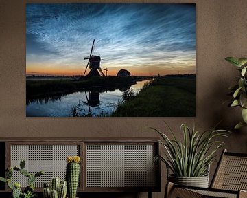 Lichtende nachtwolken boven een windmolen in het hollandse landschap van Menno van der Haven