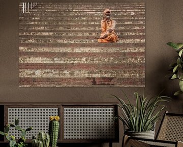 man rust op stappen van een ghat in Varanasi, India.