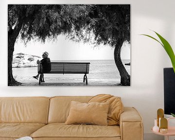 Man op bankje tussen palmbomen aan strand en zee in Puglia, Italie van Bianca ter Riet