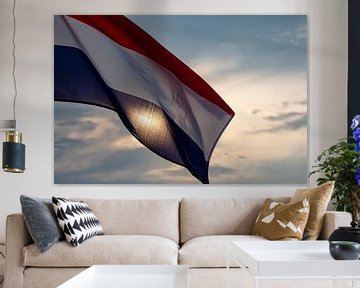 Nederlandse vlag tegen een ondergaande zon. van Femke Ketelaar