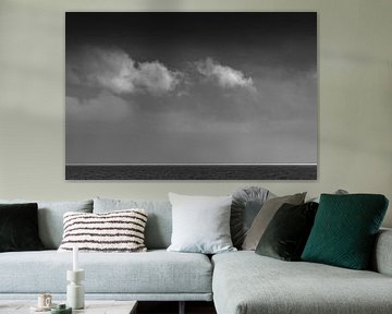 Witte wolken boven de Waddenzee met een streep wit licht aan de horizon in zwart wit van Tonko Oosterink