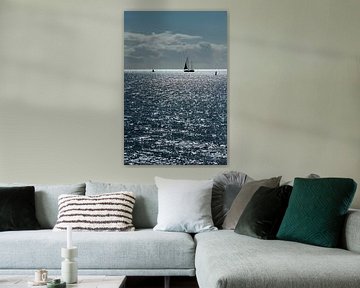 Bateau à voile contre l'éblouissement du soleil dans la mer des Wadden près de l'île de Terschelling sur Tonko Oosterink