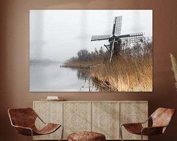 Mill in the landscape by the water on a foggy day by Marcel Kieffer