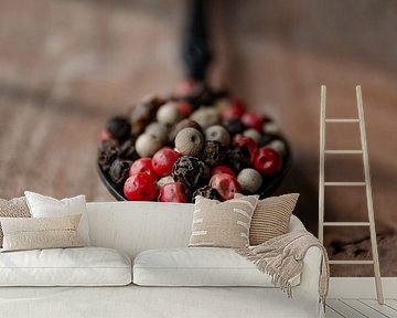Peppercorns on a black spoon and Walnut wood by RB-Photography