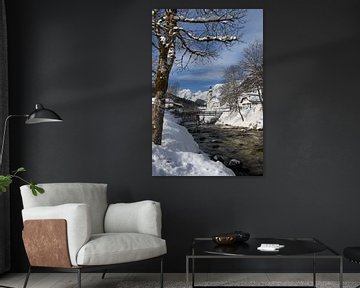 Winterlandschaft mit einer Kirche und verschneiten Alpen mit einem Bach