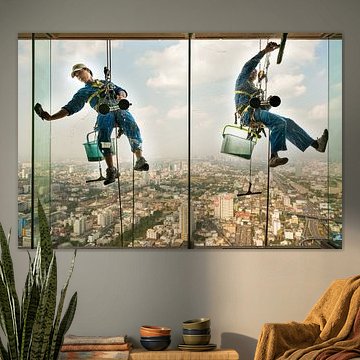 Fensterputzer hängen bei ihrer Arbeit in der Höhe von einem Wolkenkratzer