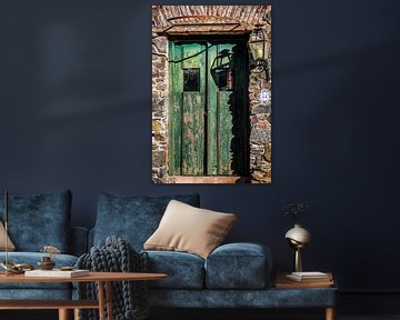 Oude groene houten deur met lantaarn aan de muur van Jan van Dasler