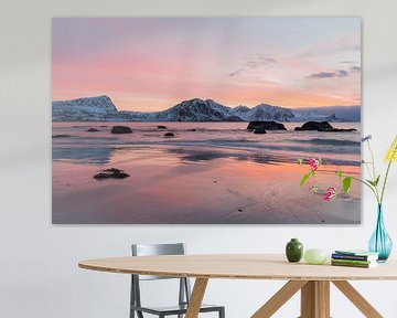 Le coucher de soleil enveloppe la mer et une plage de rochers à la lueur orange. sur Sander Groffen