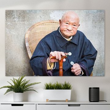 Porträt eines alten Mannes, der mit einem Spazierstock in China posiert