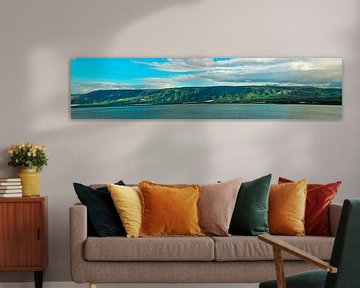 Golan Heights and Tiberian Lake panorama where green hills, blue sky with clouds and the surface of  by Michael Semenov
