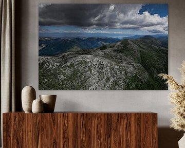 Landschaft unten (Luftaufnahme aus einem Gleitschirm) mit grünen Bergen, stark bewölkt. Montenegro von Michael Semenov
