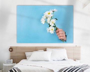 Strauß von Gänseblümchen oder Gänseblümchen, die durch eine blaue Wand geklebt sind von Atelier Liesjes