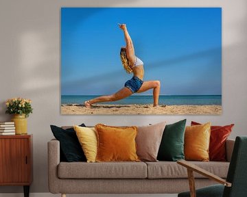 Jonge Nederlandse vrouw in zomerkleding oefent yoga op strand van Hurghada in Egypte