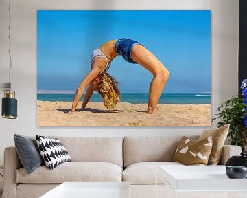 Jonge Nederlandse vrouw in bikini buigt achterover bij yoga op strand van Hurghada in Egypte van Ben Schonewille