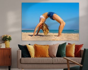 Jonge Nederlandse vrouw in bikini buigt achterover bij yoga op strand van Hurghada in Egypte van Ben Schonewille