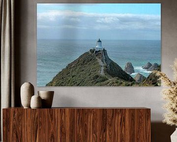 Rough coast with stones and a lighthouse by Marco Leeggangers