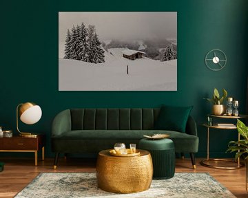 Cabane de montagne dans la neige vue du sommet nuageux sur Guido Akster