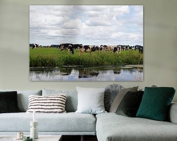 Nederlands landschap met een kudde grazende koeien in een weiland langs de sloot met daarin reflecti van Robin Verhoef