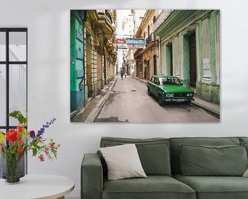 Authentic street in Havana in Cuba with green oldtimer car parked by Michiel Dros