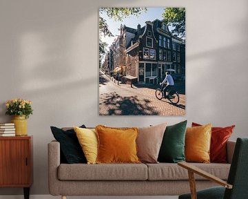 Fietser op straathoek langs de Amsterdamse grachten met typisch Amsterdamse huisjes van Michiel Dros