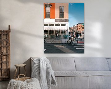 Straathoek met oranje gebouw, restaurant en fietser in Manhattan, New York van Michiel Dros