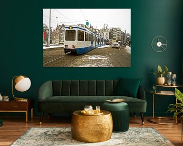 Tram rijd door een besneeuwd Amsterdam in Nederland van Eye on You