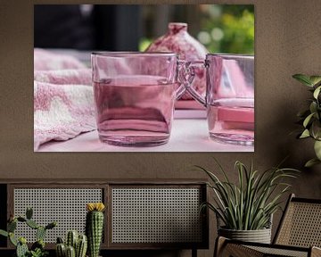 Set van roze theeglazen met vloeistof voor een met name roze achtergrond met een vaasje van Idema Media