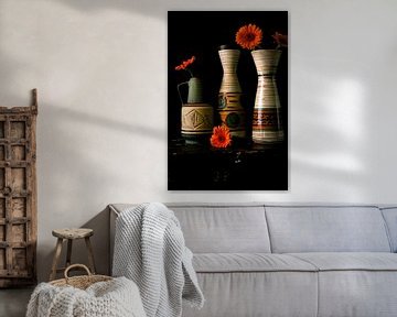 Foto van een stilleven met jaren 60 vazen en oranje gerbera's. van Therese Brals