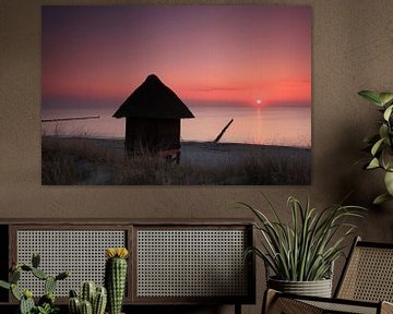 Hut op het strand bij zonsondergang