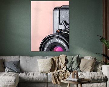 Makro-Nahaufnahme von Details einer alten 'Praktica'-Kamera mit rosa/orangem Pastellhintergrund. von Iris Koopmans