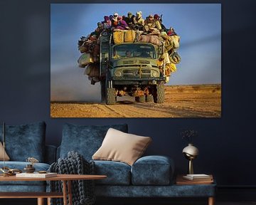 Vrachtwagen met mensen in Sahara woestijn van Frans Lemmens