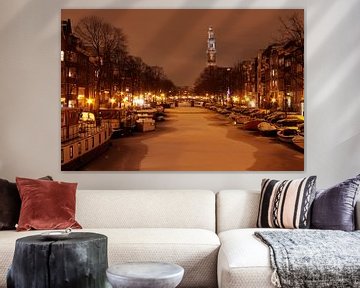 Besneeuwd Amsterdam in Nederland met de westerkerk bij avond van Eye on You