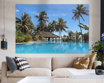 Swimming pool with palm trees and bamboo hut on tropical island by Robin Jongerden