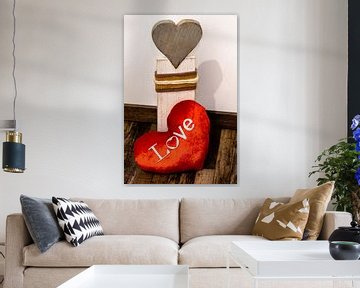 Ein Rotes Stoff Herz liegt vor einem Herz aus Holz von Tom Voelz