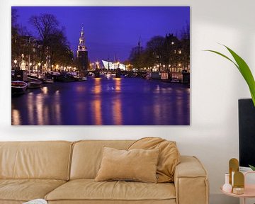 Stadsbeeld van Amsterdam met de Montelbaan toren bij avond in Nederland van Eye on You