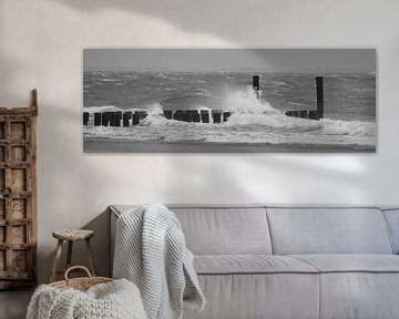 Golfbrekers met opspattend water aan Nederlandse kust zwart wit