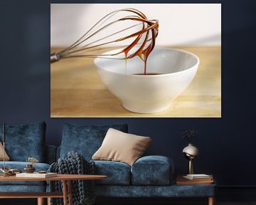 Bruine melasse stroomt van een draadklopper naar een witte kom, bakkend thuisconcept, houten tafel e van Maren Winter