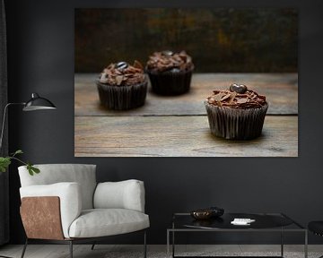 drie chocoladecupcakes met cacaobotercrème op donker hout, een is in focus, kopieerruimte, smalle sc van Maren Winter