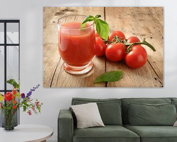 vers biologisch tomatensap in een drinkglas met peper en basilicumgarnituur op een rustieke houten p van Maren Winter