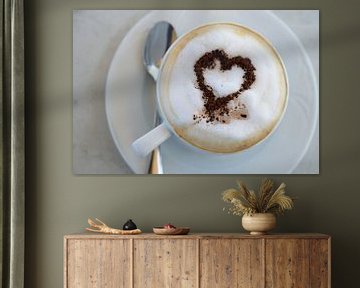 Tasse Cappuccino mit Kakaopulver in Herzform auf einem Tisch in einem Straßencafé, Hochwinkelansicht von Maren Winter