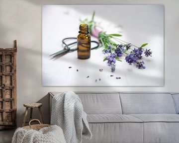 lavendelbloemen, een flesje met essentiële kruidenolie en een schaar op wit geschilderd hout, kopiee van Maren Winter