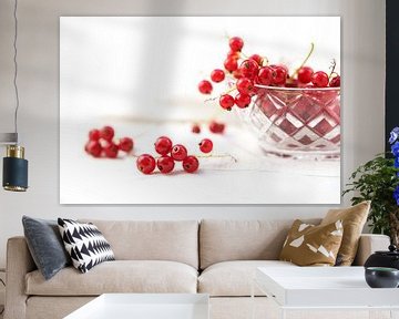 mooie rode bessen uit de tuin in een glazen schaal en op tafel, achtergrond met kopieerruimte vervaa van Maren Winter
