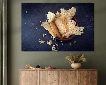 knapperige parmezaanse kaaschips, zelfgemaakte partysnack in een kom op een donkere leisteen achterg van Maren Winter