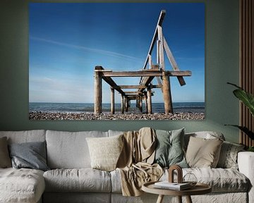 Gebroken houten pier of steiger leidt naar de zee tegen een blauwe hemel, perspectief van onderaf, k van Maren Winter