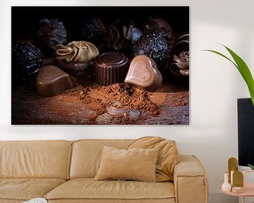 Chocoladepralines en cacaopoeder op rustiek hout als liefdesgeschenk, close up tegen een donkere ach van Maren Winter