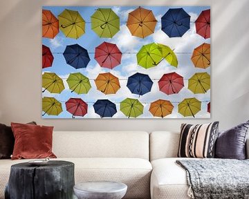 kleurrijke hangende paraplu's in de lucht, twee zijn flirten, straatdecoratie achtergrond van Maren Winter