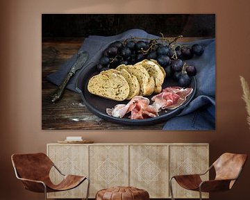 vers volkoren brood met blauwe druiven en Prosciutto ham op een donkere rustieke houten tafel, gesel van Maren Winter