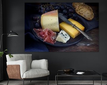 assiette de dîner avec divers fromages, jambon séché à l'air, raisins bleus et pain sur bois foncé r sur Maren Winter