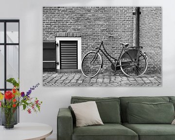 Traditionele zwarte fiets tegen een stenen muur van Tony Vingerhoets