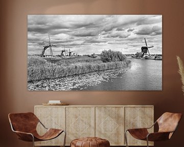Windmills near a canal with dramatic clouds by Tony Vingerhoets